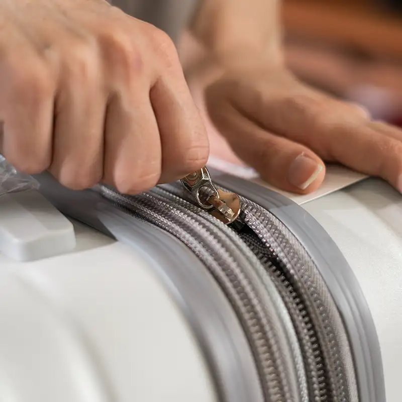 Closeup of person opening a suit case.