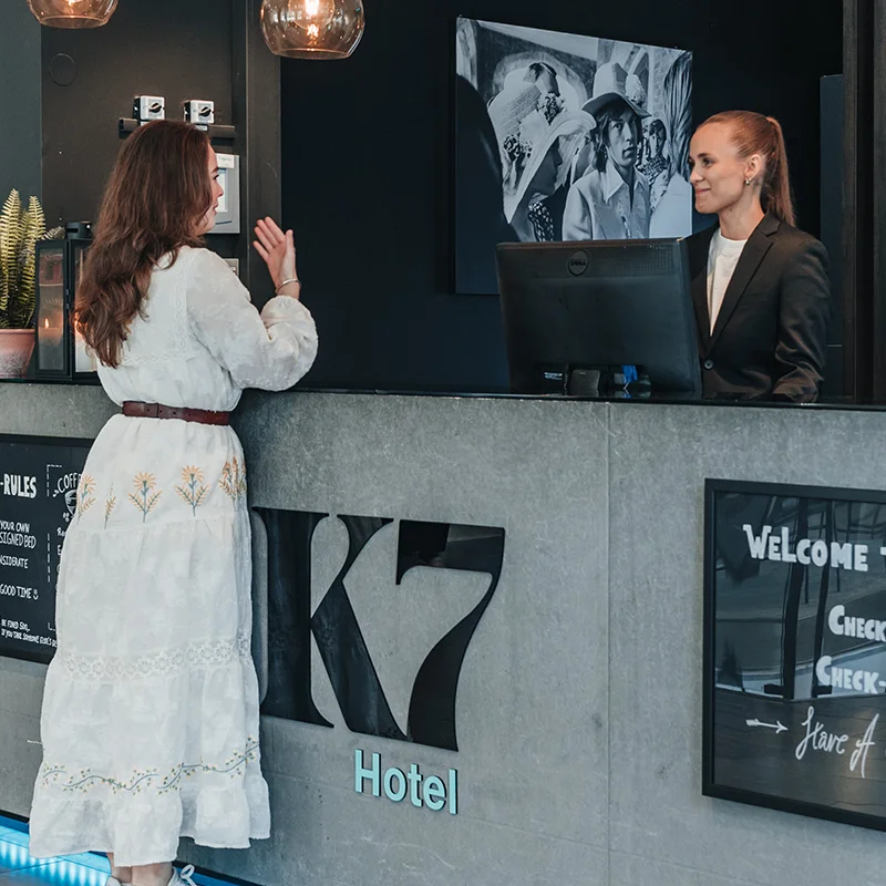 Woman talking to the receptionist in the lobby of K7 Hotel Oslo